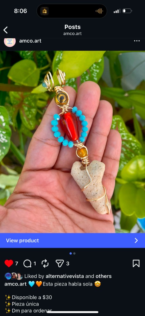 Handmade vertical wire-wrapped pendant with red teardrop bead, turquoise accents, sun motif bead, and natural coral or stone base.